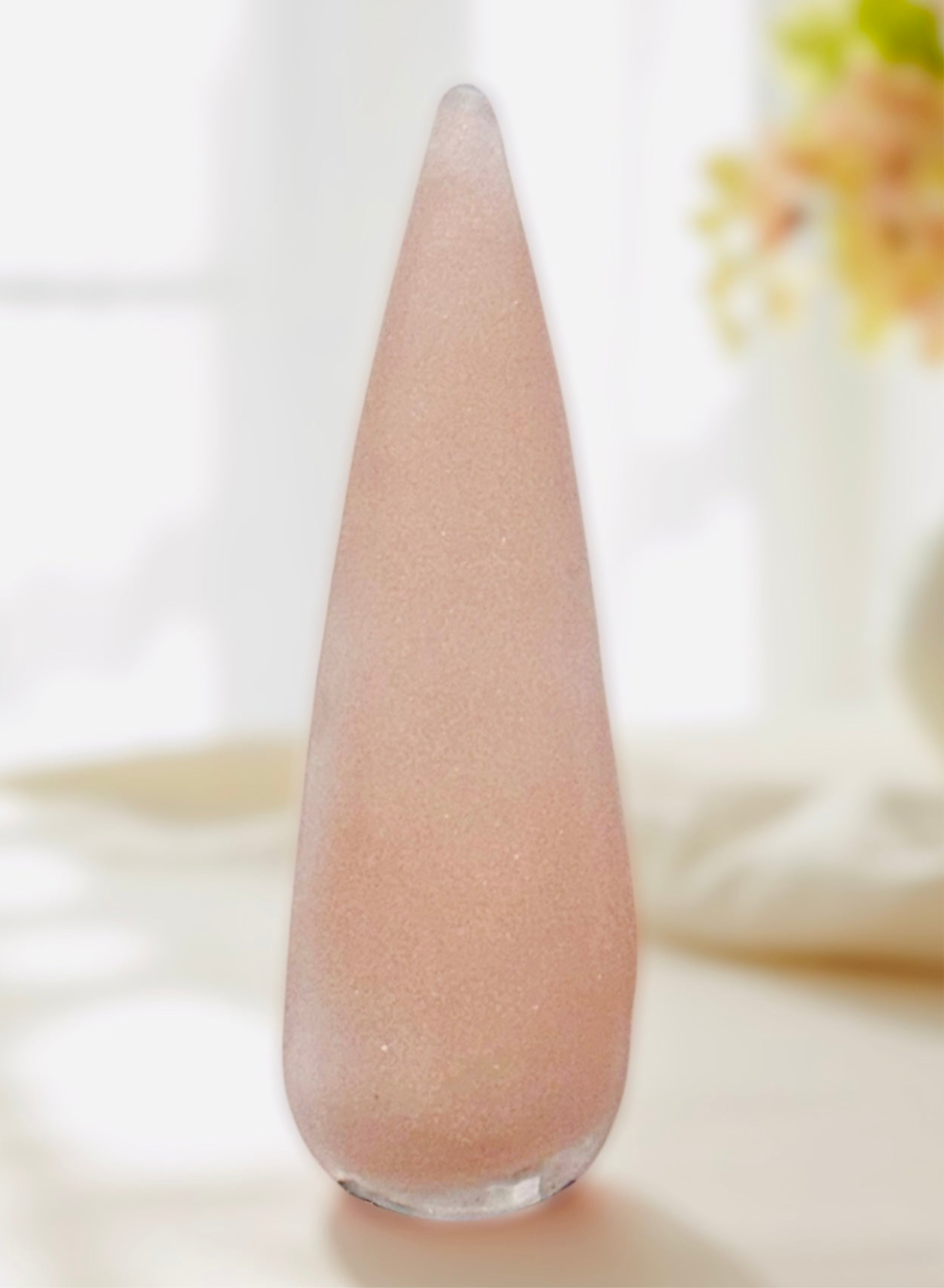 Nude Acrylics Nails powder in a sleek pointed glass container from the Color Me Nude Collection.