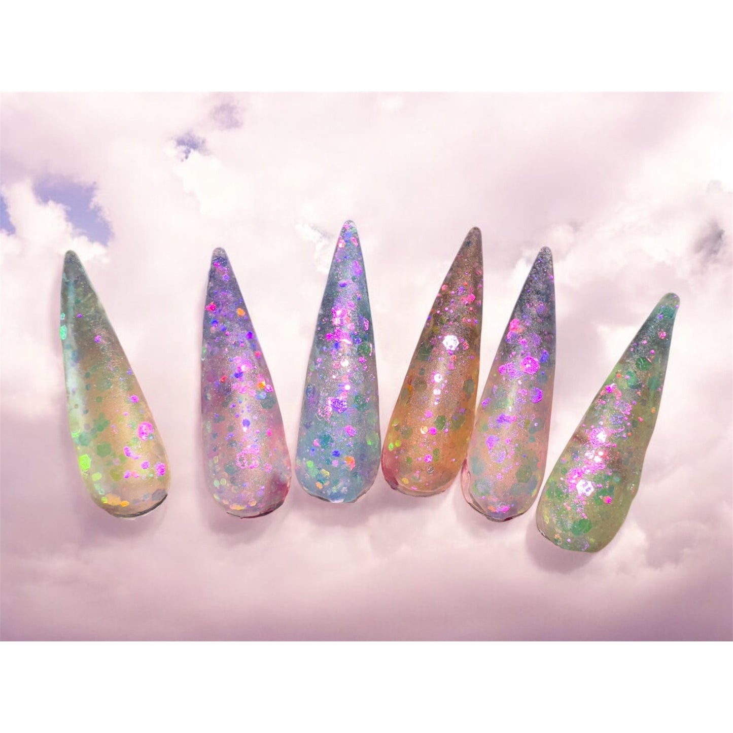 Mystical Dreams acrylic nail powders in pastel glitter, showcasing enchanting manicures against a dreamy sky background.