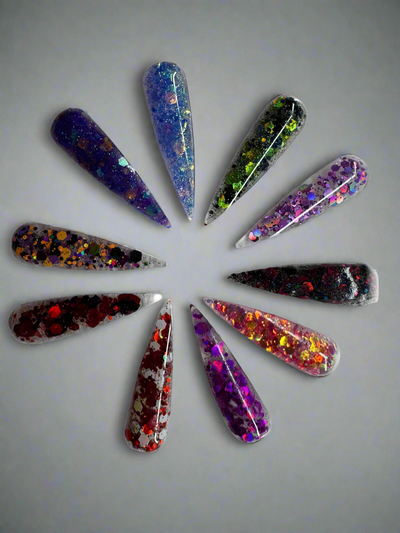 Set of long stiletto Halloween acrylic nails with chunky glitter in various spooky colors arranged in a circle